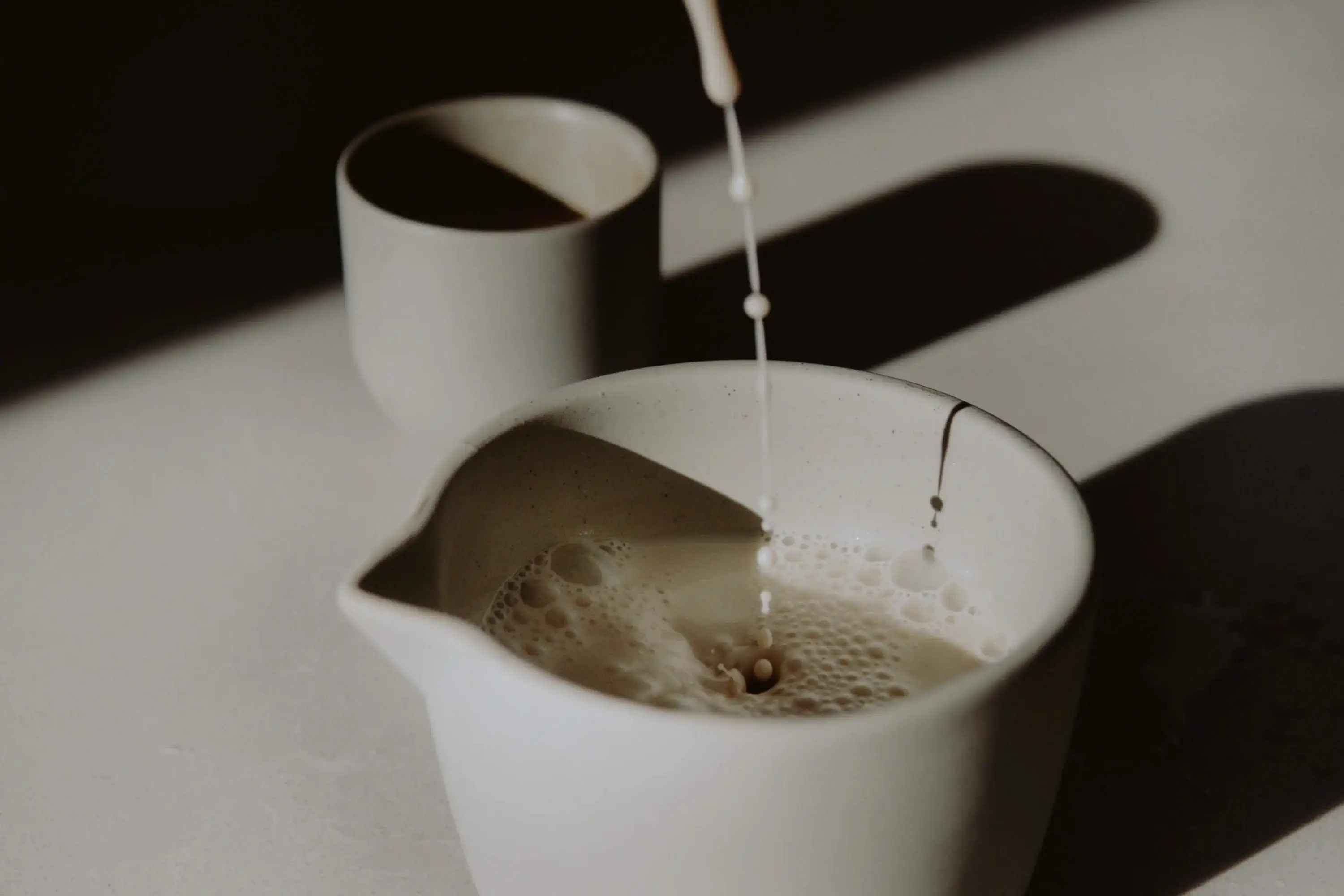 milk being poured into a cup